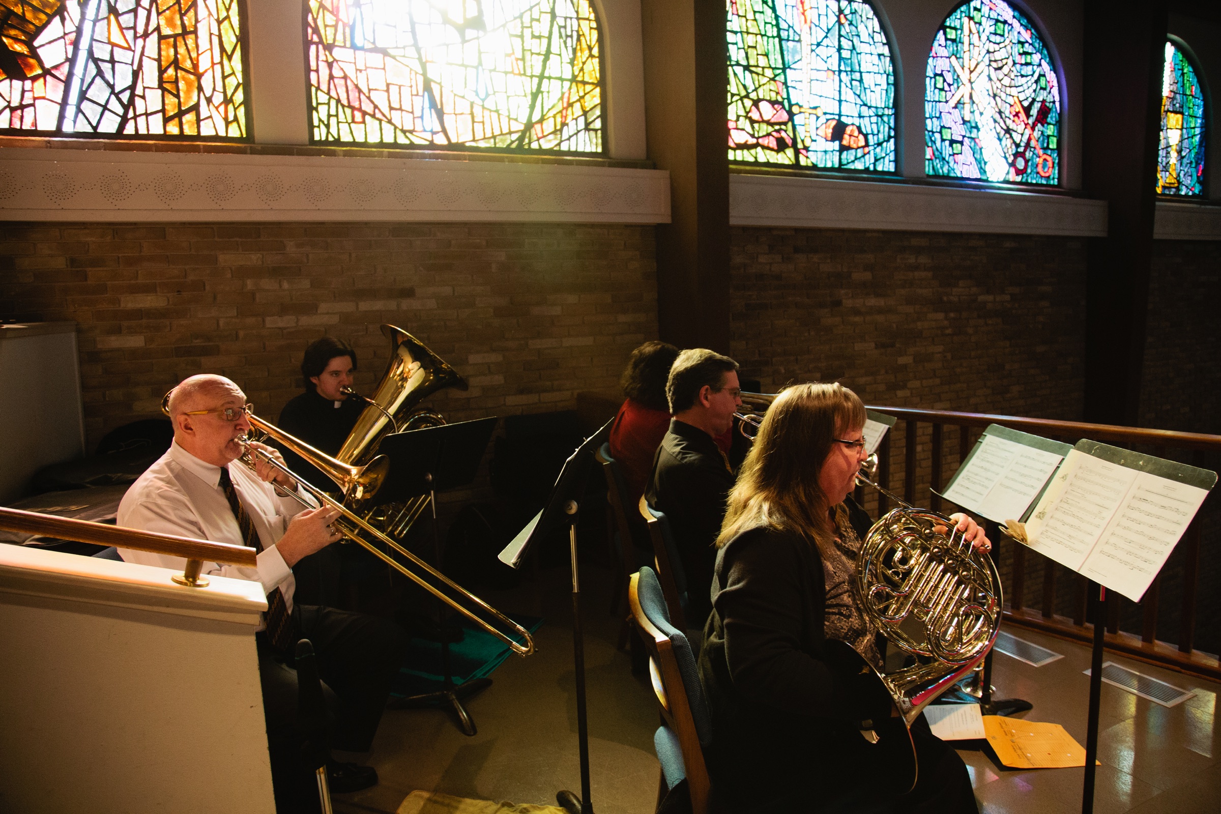 Brass musicians playing beneath the stained-glass windows at Our Redeemer